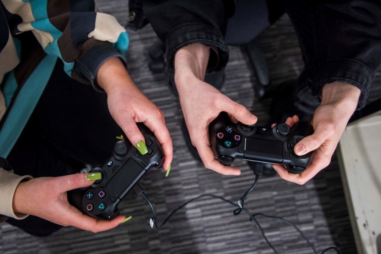 <img src="Abertay University Dundee_Accessible Gaming Symposium 2022_01_1212x808.jpg" alt="Image showing two friends holding controllers and playing a game together">